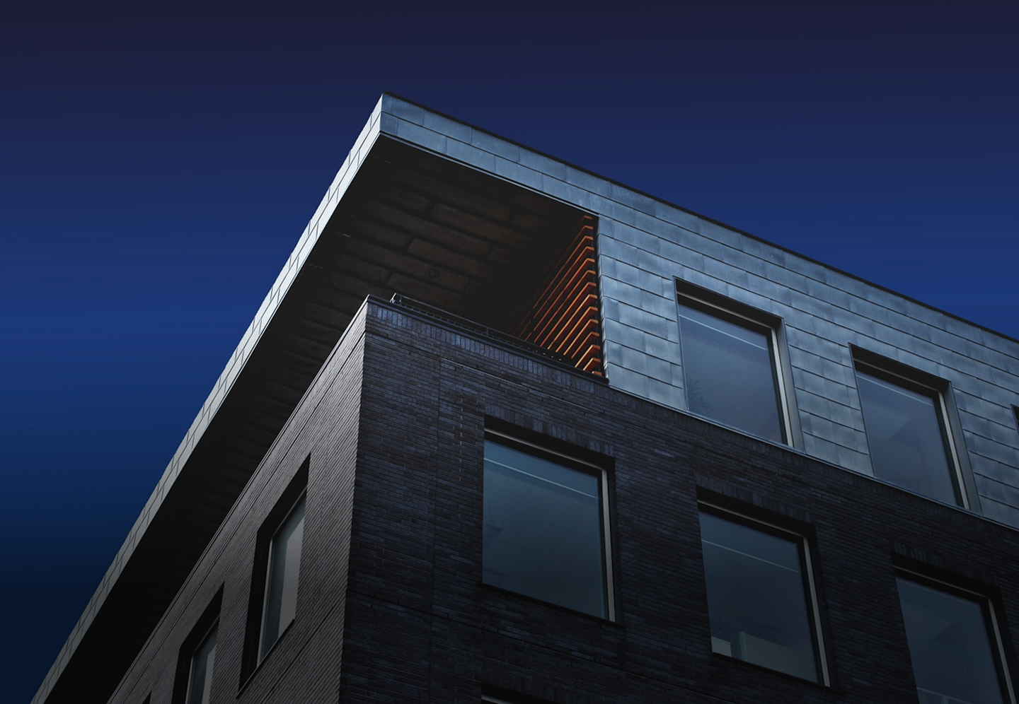 Modern residential building with dark cladding and metalwork detailing